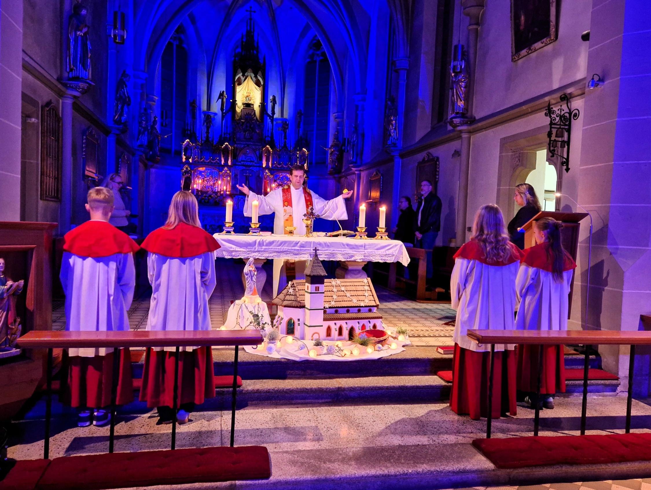 Hell leuchtet das Gnadenbild vom blau beleuchteten Hochaltar, Dekan Detlef Pötzl zelebriert den Gottesdienst SSB-Gottesdienst 25.10.26 in Steinwiesen